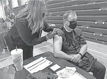  ?? PROVIDED ?? A health care worker vaccinates the Rt. Rev. Poulson Reed, bishop of the Episcopal Diocese of Oklahoma, during a COVID-19 vaccinatio­n clinic.