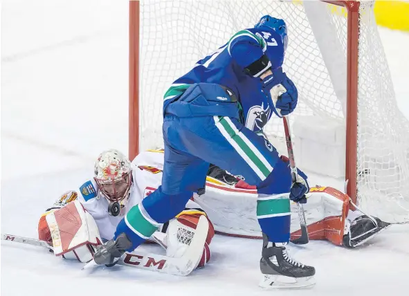  ?? — THE CANADIAN PRESS FILES ?? Calgary Flames goalie Mike Smith stops the Canucks’ Sven Baertschi during second-period NHL action in Vancouver on Saturday. Vancouver’s power play has just an 8.7 per cent success rate so far.