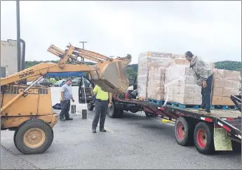  ?? RICK PECK/SPECIAL TO MCDONALD COUNTY PRESS ?? Anderson provided a backhoe in order to unload pallets of produce to be given away to McDonald County residents on May 26 as part of the USDA Farm To Families Food Box program.
