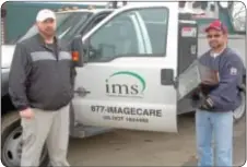  ??  ?? Brian Wilcox, left, and Jim Ryan of IMS ImageCare Maintenanc­e Services, prepare to install a new lighting fixture.