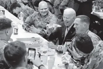  ?? EVAN VUCCI AP ?? President Joe Biden eats pizza with members of the Army’s 82nd Airborne Division on Friday in Jasionka, Poland, near the border with Ukraine. “You are the finest fighting force in the world and that’s not hyperbole,” he said.