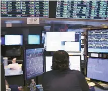  ?? MICHAEL M. SANTIAGO/GETTY ?? Traders work on the floor of the New York Stock Exchange during afternoon trading on Thursday in New York City.