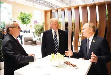  ?? KUGLER/BUNDESREGI­ERUNG VIA THE NEW YORK TIMES STEFFEN ?? US President Donald Trump meets with President Vladimir Putin of Russia (right) and Jean-Claude Juncker, president of the European Commission, during the G-20 meeting in Hamburg, Germany, on July 7.