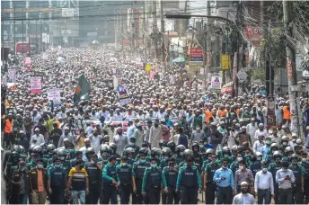  ?? — AFP photo ?? Activists and supporters of the Islami Andolon Bangladesh, a Islamist political party, hold a protest march calling for the boycott of French products and denouncing Macron for his comments over Prophet Mohammed caricature­s, in Dhaka.