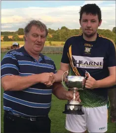  ??  ?? Oliver O’Leary of Buffers Alley receives the cup from Michael Maguire (Gorey District Secretary).