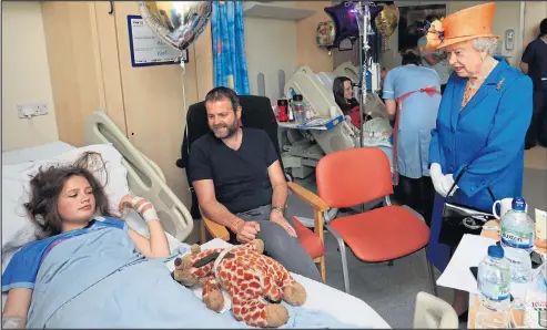  ??  ?? Her Majesty talks to 14-year-old Evie Mills and father Craig during her visit to Manchester Royal Children’s Hospital yesterday