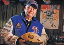  ?? CP PHOTO ?? Donald Crisman poses with memorabili­a from the 51 Super Bowls he has attended so far, at his home in Kennebunk, Maine.