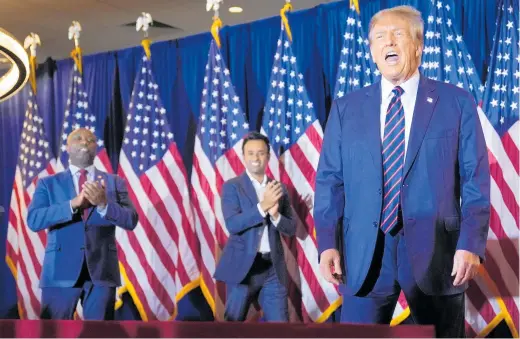  ?? Photo / AP ?? Republican Senator Tim Scott (left) and former presidenti­al candidate Vivek Ramaswamy support Donald Trump as he seeks to gain the party’s nomination to run for president.