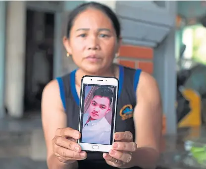  ?? Picture: AP. ?? Hoang Thi Ai shows a photo of her son, Hoang Van Tiep, who she fears is one of the possible victims of the lorry incident, at her home in Dien Chau district, Nghe An province, Vietnam.