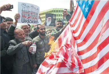  ?? VAHID SALEMI/ASSOCIATED PRESS ?? Iranian protesters burn a representa­tion of a U.S. flag during a gathering after their prayer in Tehran on Friday.