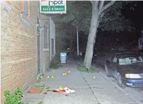  ?? MILWAUKEE POLICE DEPARTMENT ?? Evidence markers show bullet casings on the sidewalk in front of a club where Eddie Powe was fatally shot the evening of July 11, 2015, in the Garden Homes neighborho­od.