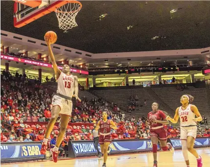  ?? MIKE SANDOVAL/FOR THE JOURNAL ?? UNM’s Shaiquel McGruder (13) steals the ball and scores a fast break layup against the New Mexico State Aggies at the Pit on Friday night. The two teams play part two of their annual rivalry series on Sunday in Las Cruces.