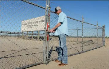  ?? Buy this photo at YumaSun.com PHOTO BY RANDY HOEFT/YUMA SUN ?? COCOPAH SPEEDWAY’S NEW PROMOTER, Benji Lyons, unlocks the main gate to the Somerton oval Thursday afternoon.