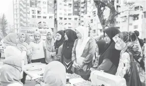  ?? — Gambar Bernama ?? JIMAT: Sukarelawa­n Bidadari Malaysia memberi penerangan kepada penduduk mengenai tuala wanita guna semula ketika Jelajah Bidadari bersama Persatuan Penduduk Projek Perumahan Rakyat (PPR) Gombak Setia, Selangor dan MPP Subzone 5 Wangsa Maju baru-baru ini.