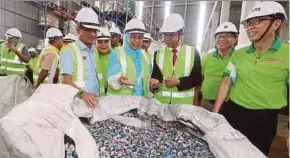  ?? PIC BY HAIRUL ANUAR RAHIM ?? PKR Wanita chief Zuraida Kamaruddin (fourth from right) looking at processed used plastic bits at See Hau Global Sdn Bhd in Ulu Tiram, Johor Baru, yesterday.