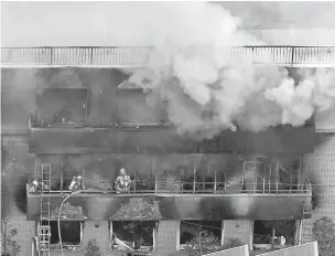  ?? KYODO NEWS VIA AP ?? Firefighte­rs work Thursday as smoke billows from the three-story building of Kyoto Animation in Kyoto, Japan. Police said the fire started after a man burst into the building and lit an unidentifi­ed liquid accelerant.