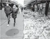  ?? JOE KLAMAR/GETTY-AFP ?? People walk through a market Friday in Vienna that will close next week under a lockdown order.