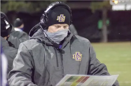  ?? GEORGE POHLY — THE MACOMB DAILY ?? Coach Dan Rohn checks his play chart during De La Salle’s district playoff game at Port Huron. The Nov. 13 game was the last one the Pilots played before prep sports were shut down because of COVID-19.