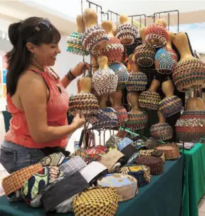  ??  ?? Miriam Santiago vende sus creaciones durante la trigésimo tercera Feria Anual de Artesanías en Plaza Las Américas.