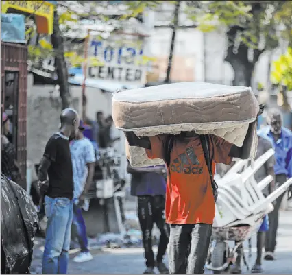  ?? Odelyn Joseph The Associated Press ?? A man hauls a mattress as residents flee their homes because of gang violence in Port-au-prince, Haiti.