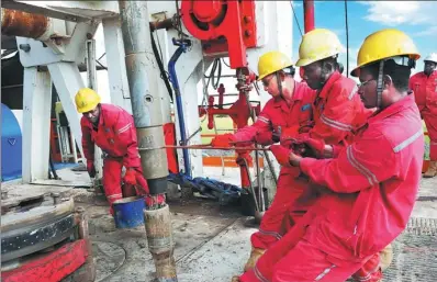  ?? TONG JIANG / FOR CHINA DAILY ?? Chinese and Sudanese employees work at a Sinopec oilfield in Sudan.