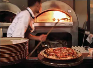  ??  ?? The wood-fired oven allows the chefs to get the coveted ‘leopard spots’ on the dough, an important considerat­ion in artisanal pizzas.