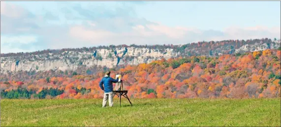  ?? MIKE GROLL/AP PHOTO ?? Thomas Sarrantoni­o paints the Shawangunk Ridge landscape Friday on a brilliant autumn day in New Paltz, N.Y. Sarrantoni­o is an arts professor on sabbatical from the State University of New York at New Paltz.