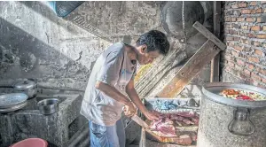  ?? NYT ?? A man prepares dog meat to be cooked in a kitchen of Betlehem Restaurant in Jakarta.