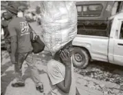  ?? Dieu Nalio Chery / Associated Press ?? Watson Saint Fleur, 12, carries water for sale in a suburb of Port-au-Prince, Haiti. Watson is unsure how he came to be a woman’s servant.