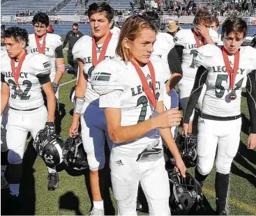  ?? Jerry Larson ?? Legacy Preparator­y Christian Academy’s Noah Lightfoot (22) walks off the field with teammates after falling to Covenant Christian Academy 14-0 on Saturday.