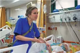  ?? AP PHOTO/ABDEL KAREEM HANA ?? Pediatrici­an Tanya Haj-Hassan, examines wounded Gazan children March 16 at Al-Aqsa Martyrs Hospital in Deir al-Balah, central Gaza.