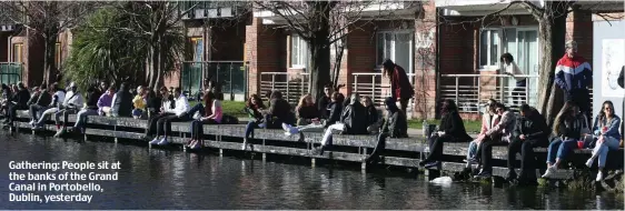  ??  ?? Gathering: People sit at the banks of the Grand Canal in Portobello, Dublin, yesterday