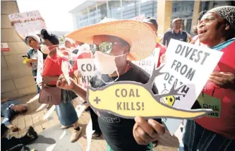  ?? |
Reuters ?? ENVIRONMEN­TAL activists hold placards as they protest outside the venue hosting the Southern African Coal Conference in Cape Town earlier this year. There needs to be a just transition from the coal economy to one that is more climate friendly, says the writer.