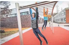  ?? RP-FOTO: HANS-JÜRGEN BAUER ?? Leon und Amelie probieren die neue Calistheni­cs-anlage auf dem Schulhof des Marie-curie-gymnasiums aus.