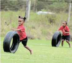  ?? SUPPLIED Picture: ?? NON-TIRING FUN: Two of the participan­ts push forward in one of the fun events making up the foundation phase sports day at Holy Cross School on the Highlands road last week. Principal Nicci Hayes said the school focussed on skillsdeve­loping races, and the tyre chase was one of those.