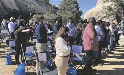  ?? AP PHOTO/ELLIOT SPAGAT ?? People take part in a naturaliza­tion ceremony to become U.S. citizens, on May 4 in Joshua Tree National Park, Calif.