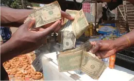  ?? ?? Street traders with US dollars at a market in Glen Norah, Harare. Money dealers say they are being scapegoate­d in a government crackdown that blames them for a drop in the value of the Zimbabwean dollar. Photograph: Nyasha Chingono