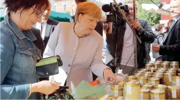  ?? AFP ?? Miele per Angela. In campagna elettorale nel Land del Meclemburg­o-Pomerania, la signora Merkel ha visitato un mercatino a Ribnitz-Damgarten