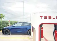  ?? ?? Tesla supercharg­ing stations near a gas station in Austin, Texas, U.S., April 23, 2024.