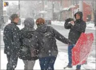  ?? PETE BANNAN — DIGITAL FIRST MEDIA ?? A group of employees of Teva Pharmaceut­icals, who live in Isreal and Ireland, and rarely see snow pose for photos in front of the Historic Chester County Courthouse during Wednesday’s snowstorm.