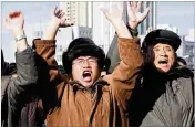  ?? JON CHOL JIN / AP ?? North Koreans at the Pyongyang Train Station in the country’s capital cheer Wednesday as they watch a news broadcast announcing the successful test launch of a powerful ICBM.