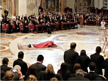  ?? AP Photo/Andrew Medichini ?? ■ Pope Francis lies down in prayer during the Good Friday Passion of Christ Mass inside St. Peter’s Basilica at the Vatican. The pontiff later traveled to the ancient Colosseum in Rome for the traditiona­l Way of the Cross procession.
