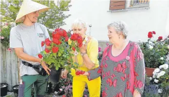  ?? FOTO: JOSEF ASSFALG ?? Die Organisato­rinnen Verena Löbel (Mitte) und Anne Ottenbache­r-Hopf (rechts) testeten bei Manuel Sommer bei ihrem Rundgang den Duft der verschiede­nen Rosen.