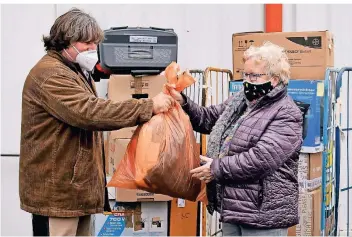  ?? FOTO: NORBERT PRÜMEN ?? Marianne Lurz bringt Spenden für die Rumänienhi­lfe. In deren Lager in St. Tönis werden sie von Hubert Stassen in Empfang genommen. In der ersten Dezemberwo­che sollen sie nach Caransebes transporti­ert werden.