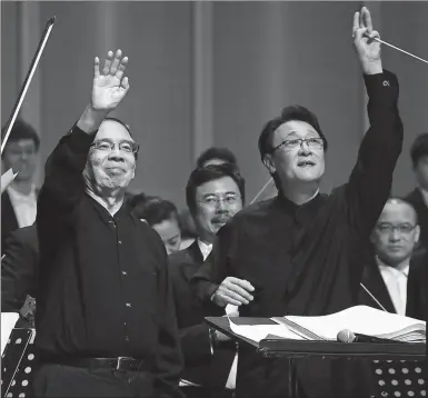  ?? PROVIDED TO CHINA DAILY ?? Conductor Tan Lihua (right) leads the Beijing Symphony Orchestra to perform Peking Opera Symphony by Bao Yuankai (left) at the ongoing Beijing Music Festival.