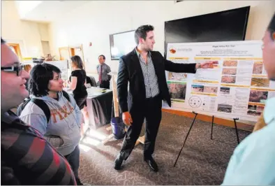  ?? CHASE STEVENS/ LAS VEGAS REVIEW-JOURNAL ?? Ben Green of the Vegas Valley Rim Trail project talks about the design of a trail alignment for the Las Vegas Valley during the Senior Design Competitio­n in the Foundation­s Building at UNLV on Thursday.