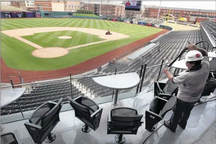  ?? PHOTOS BY NIKKI BOERTMAN/THE COMMERCIAL APPEAL ?? Jose Araiza power washes a new four-top seating area behind home plate at AutoZone Park. The minor league baseball gem that opened in 2000 received a $6.5 million renovation. Part of the parent St. Louis Cardinals’ plan was to create a more intimate...