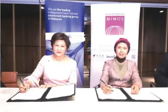  ??  ?? Maimoonah (left) and MIMOS interim president and chief executive officer Emelia Matrahah signing the document to signify the strategic collaborat­ion.