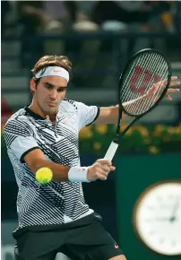  ??  ?? Roger Federer plays a backhand shot against Evgeny Donskoy.