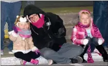  ?? Photo by Mike Eckels ?? A mother and her two daughters wait on the curb of Main Street for the start of the 2016 Decatur Christmas Parade on Dec. 9 in downtown Decatur.